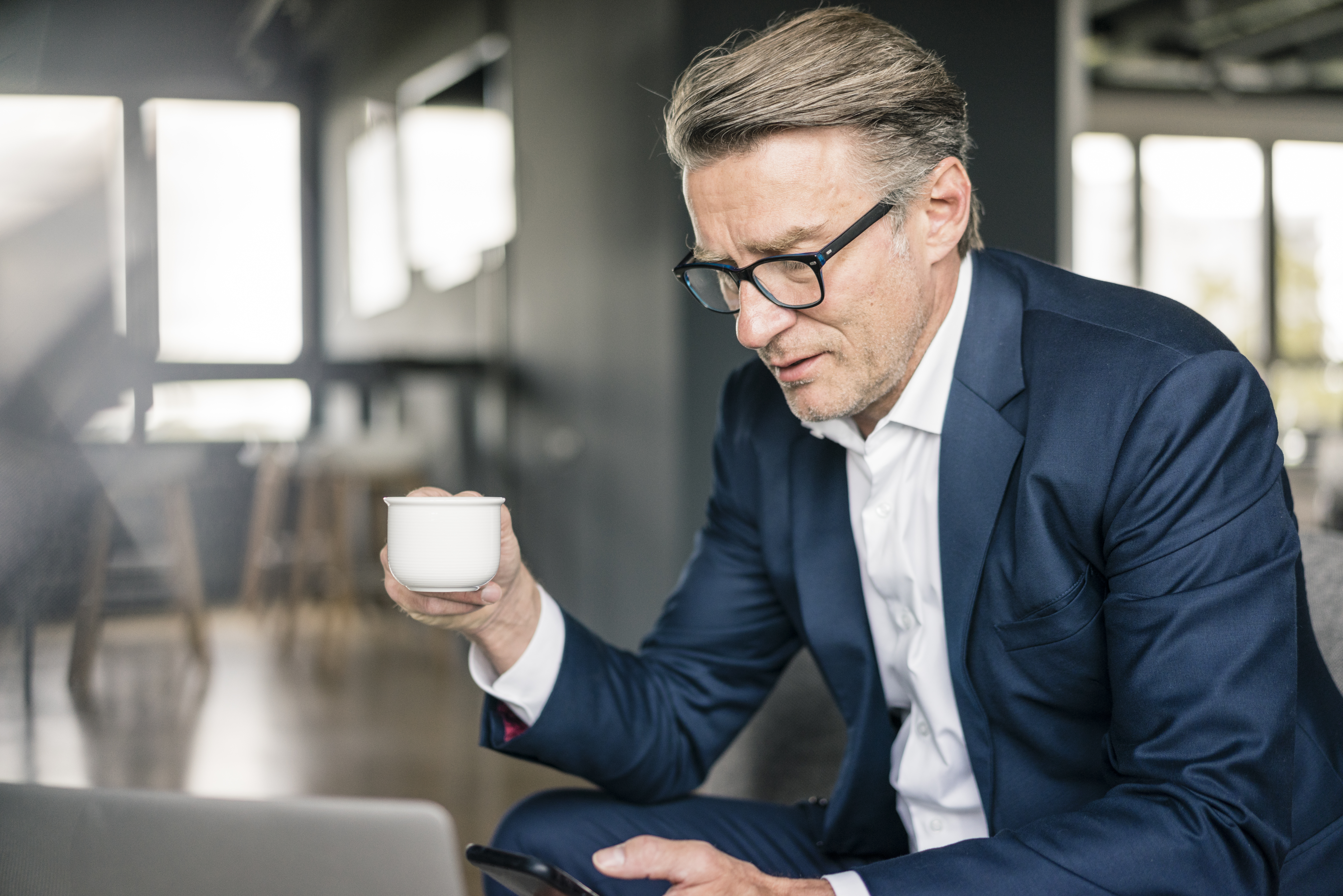 mature-businessman-with-cup-of-coffee-and-laptop-u-2022-03-08-01-22-12-utc.jpg